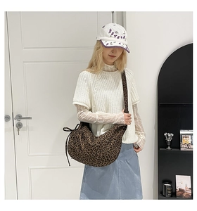 Detail of vintage leopard print crossbody bag with side drawstring and canvas texture