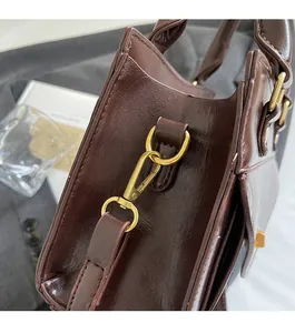 Close-up of premium dark brown leather handbag with vintage gold-tone hardware and stitching