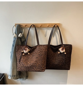 Detail of leopard print tote bags in light and dark brown with cute bear charms