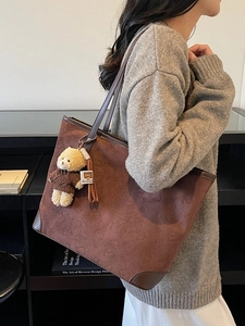 Brown vintage tote bag with embossed bear patterns and plush bear charm for daily use
