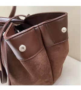 Detail of dark brown leather and suede texture with a round silver metal buckle