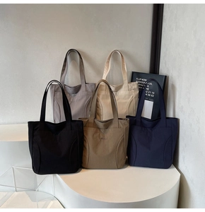 Detail shot of canvas tote bags in five colors on geometric stands with Medeia embroidery