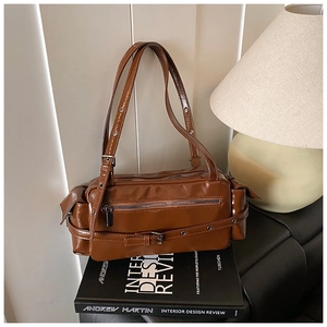 Close-up of vintage brown glossy leather shoulder bag with functional zippers and buckles