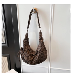 Detailed close-up of leopard print hobo bag with wide strap and drawstring detail