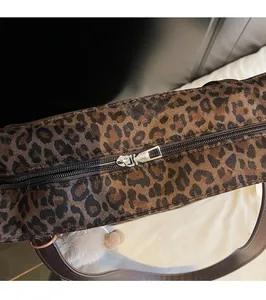 Close-up of a silver metal zipper on a leopard print faux fur tote bag showing texture