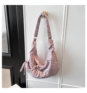 Detail of leopard print crescent bag with adjustable strap and side drawstring texture