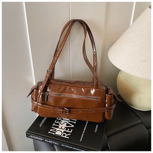 Detail of a brown oil wax leather shoulder bag with silver buckle and side pocket