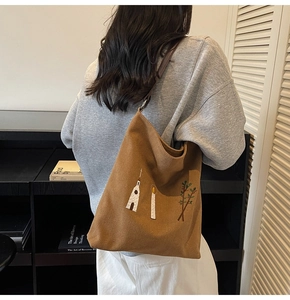 Close-up of vintage brown canvas tote bag featuring floral embroidery and slim straps