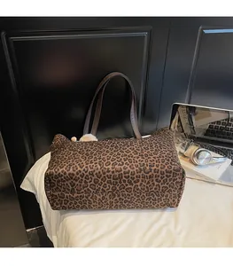 Detailed view of leopard print tote bag placed with laptop and books for commute