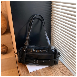 Detail of glossy black Boston bag featuring punk style metal eyelet belts and zip pockets