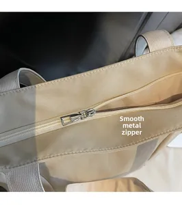Detail of high-quality smooth metal zipper and hardware on a khaki canvas tote bag