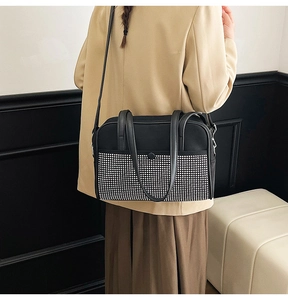 Detailed view of silver rhinestones on a black evening bag with elegant silver hardware