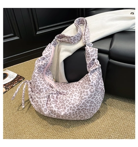 Detail of pink leopard print crossbody bag with pleated crescent design and wide strap