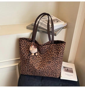 Détail du cabas imprimé léopard avec bandoulière en cuir marron et breloque peluche