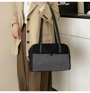 Detail of a black evening bag with dense silver rhinestones and long leather shoulder strap