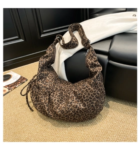 Detail of adjustable wide strap and leopard print fabric on large crescent hobo bag