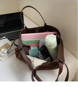 Top view showing the spacious interior of the brown suede tote bag with daily essentials