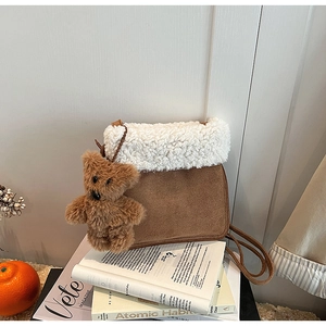 Brown faux suede shoulder bag with white fleece trim and cute plush bear charm on books