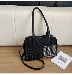 Close-up of black shoulder bag featuring unique contrast silver and black rivet details