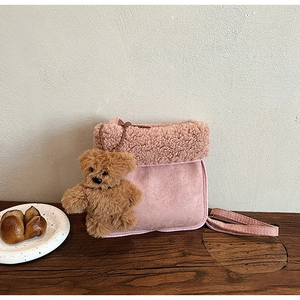Detail of pink plush crossbody bag with sherpa trim and cute brown bear keychain