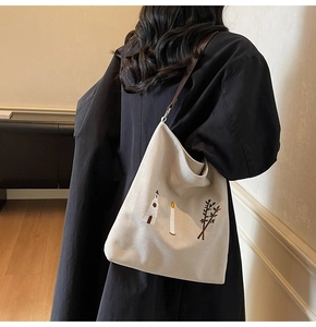 Close-up of vintage canvas tote bag featuring intricate church and botanical embroidery