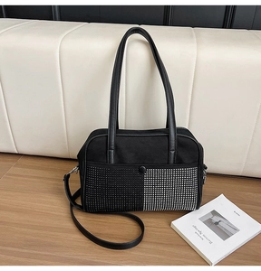 Close-up of black suede handbag with vertical rhinestone contrast and leather strap