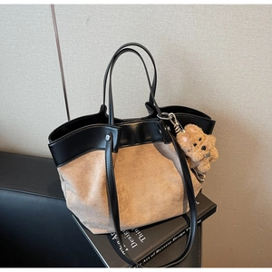 Detail of dual-material tote bag featuring smooth black leather and khaki suede textures