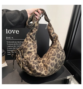 Detail of leopard print crescent bag with drawstring texture and adjustable strap