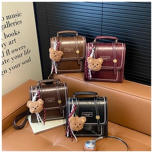 Detail view of retro leather mini backpacks in four colors with teddy bear charms