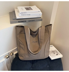 Detailed view of Midolai embroidered canvas tote bag showing stitching and wide shoulder straps