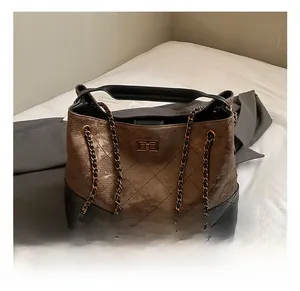 Detail view of bronze metallic and black leather patchwork with quilted diamond pattern