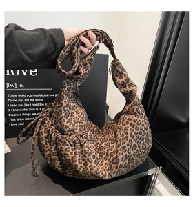Detail of vintage leopard print crescent bag featuring drawstring side and textile texture