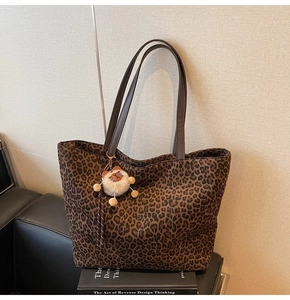 Détail du sac cabas léopard avec lanières en cuir marron et pendentif ours en peluche