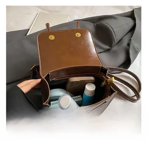 Internal view of the brown leather backpack showing spacious compartments and magnetic snaps