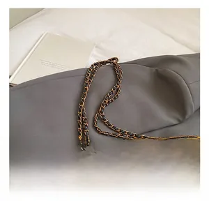Close-up of brown quilted chain bag with vintage gold metal twist lock detail