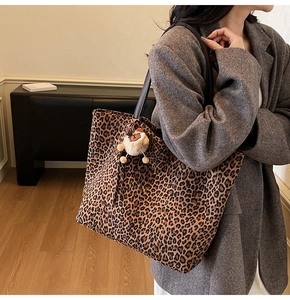 Détail d'un grand cabas léopard avec charme d'ours en peluche porté par un mannequin