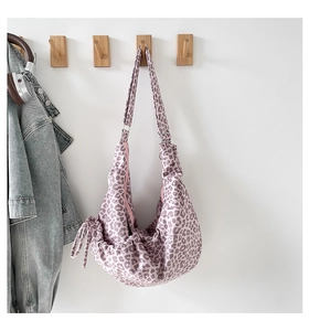 Detail of lavender leopard print crossbody bag with drawstring closure and wide strap