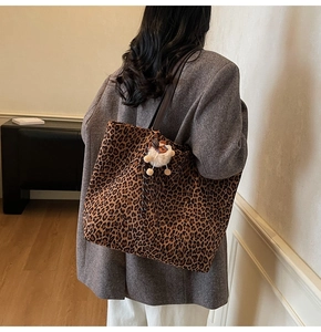 Grand cabas léopard avec pendentif en peluche porté par un mannequin en manteau
