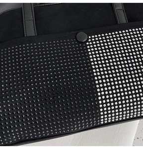 Macro detail of hand-set rhinestones and matte black leather on luxury evening bag