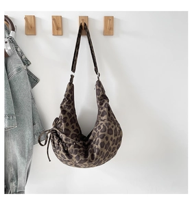 Detail of leopard print canvas bag showing textured fabric and drawstring side closure