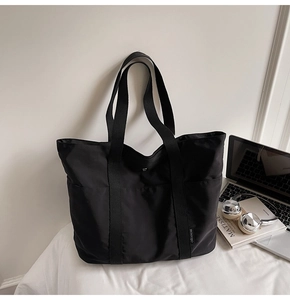 Close-up of black nylon tote bag with wide straps and spacious interior for office work