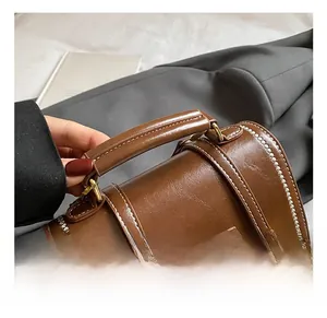 Close-up of the reinforced dark brown leather handle with stylish white stitching detail