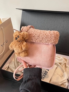 Pink plush crossbody bucket bag with faux shearling trim and brown bear charm in gift box