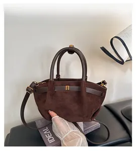 Detail of dark brown frosted leather handbag with vintage buckle and golden hardware