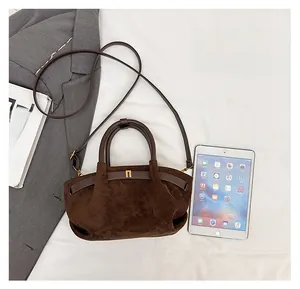 Deep brown suede handbag size comparison with tablet showing practical capacity