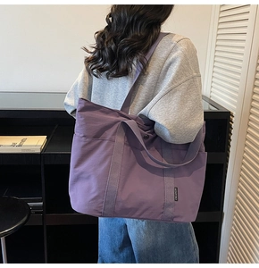 Detail of purple large-capacity tote bag with side pocket and wide shoulder strap