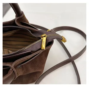 Detail of vintage gold zipper and leopard print lining on dark brown suede handbag