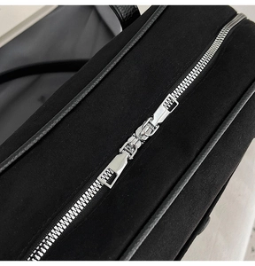 Macro detail of silver dual metal zippers on a black rhinestone evening shoulder bag