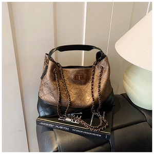 Detail of vintage quilted chain tote bag with bronze finish and black leather trim