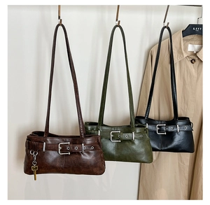 Three retro faux leather shoulder bags in brown, green, and black with buckle details